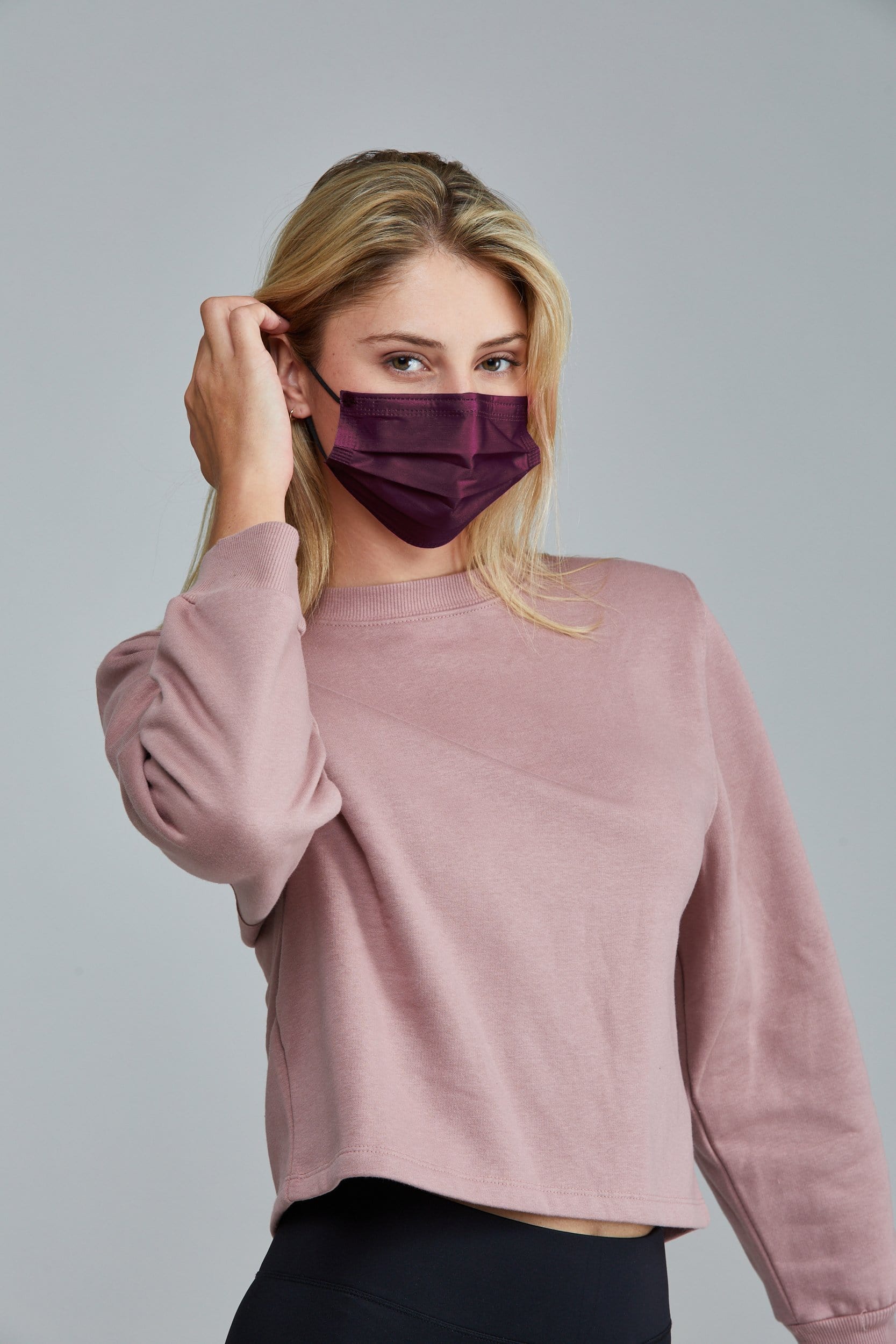 Woman wearing stylish Burgundy colored Pleated face mask, with three layers & high quality breathable fabric.