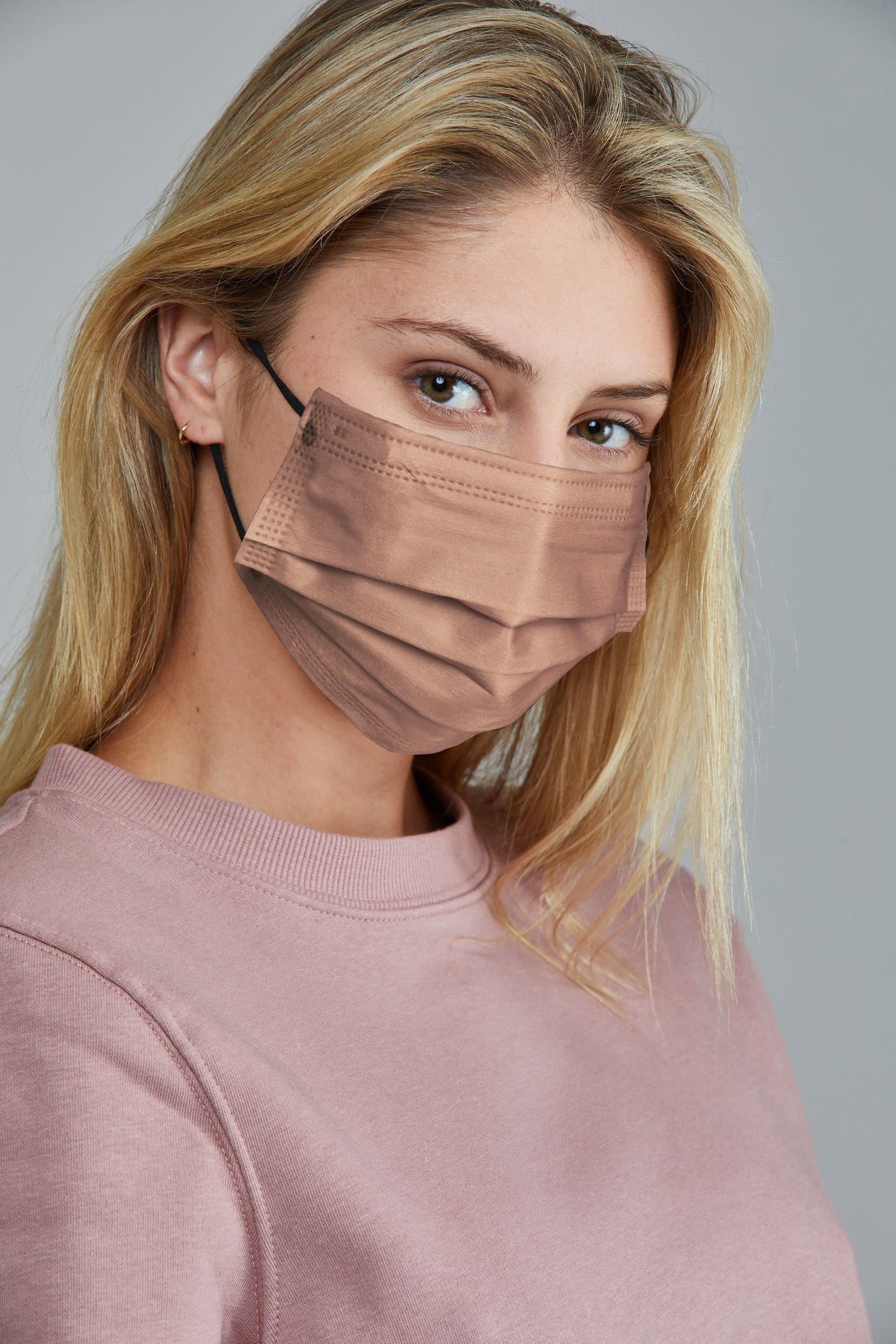 Woman wearing stylish Cream Pleated face mask, with high quality breathable fabric.