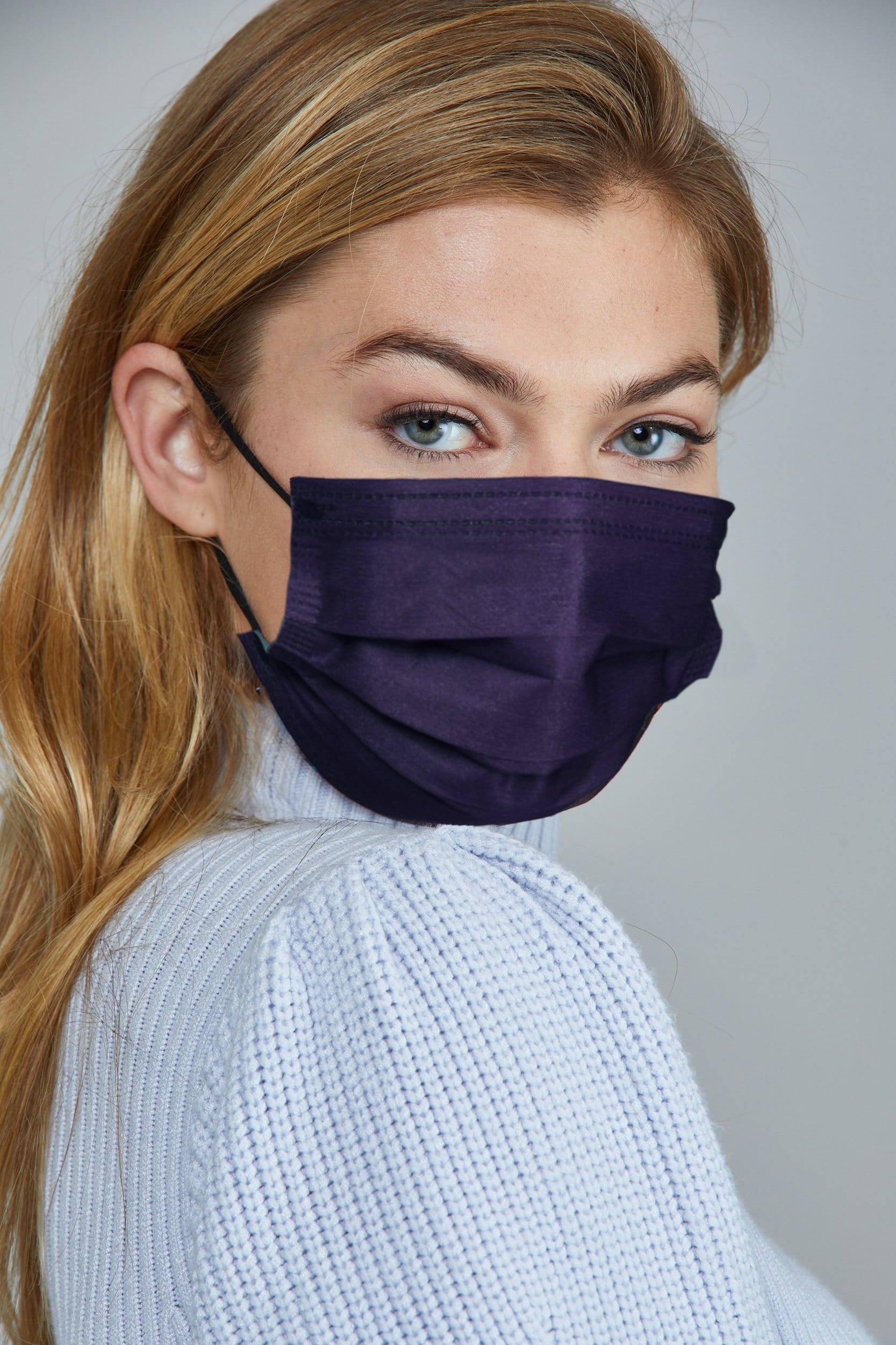 Woman wearing stylish Dark Blue Pleated face mask, with three layers & high quality breathable fabric.