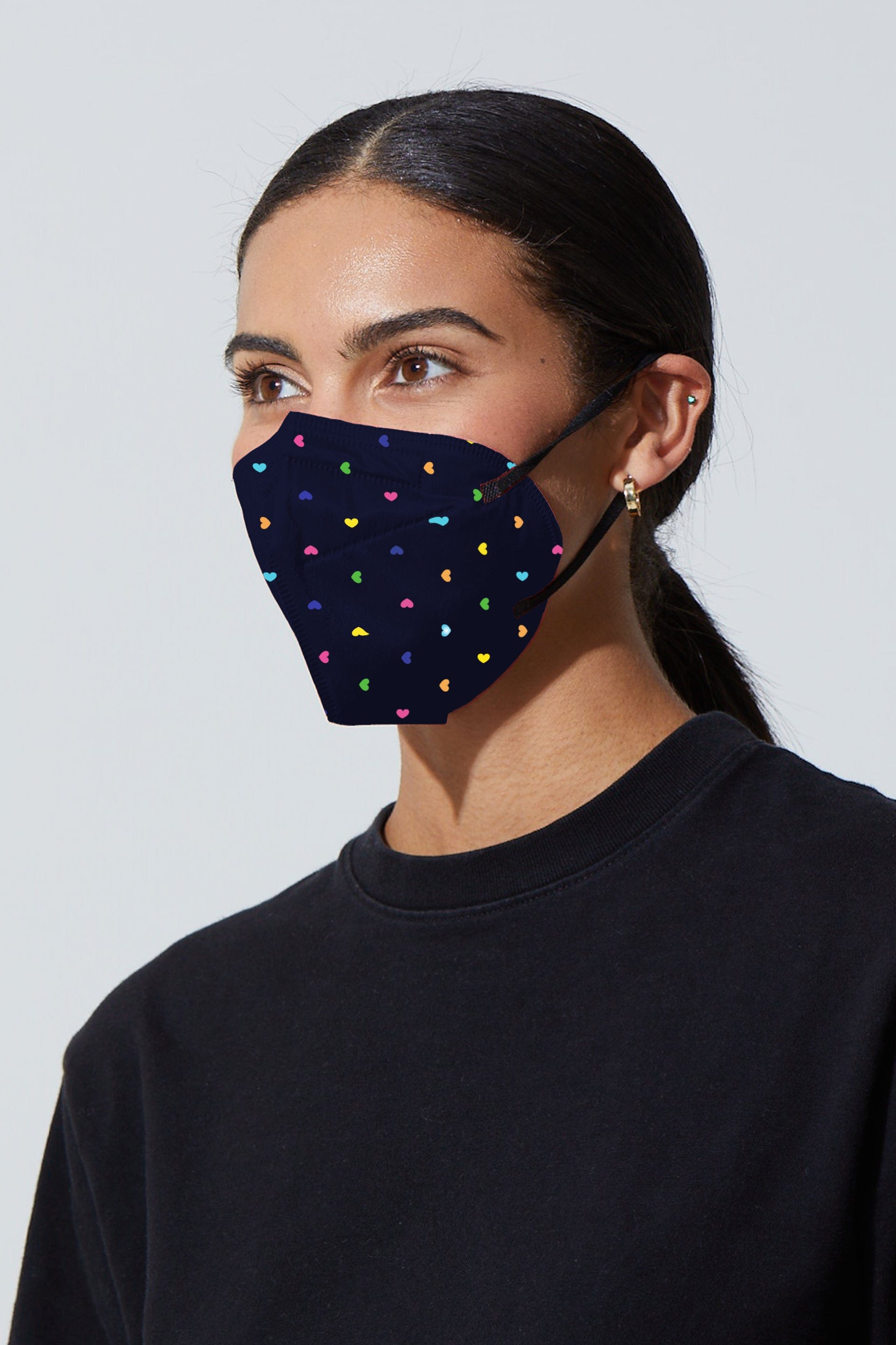 Woman wearing stylish Dark Navy KN95 face mask with colorful printed hearts, with high quality breathable fabric.