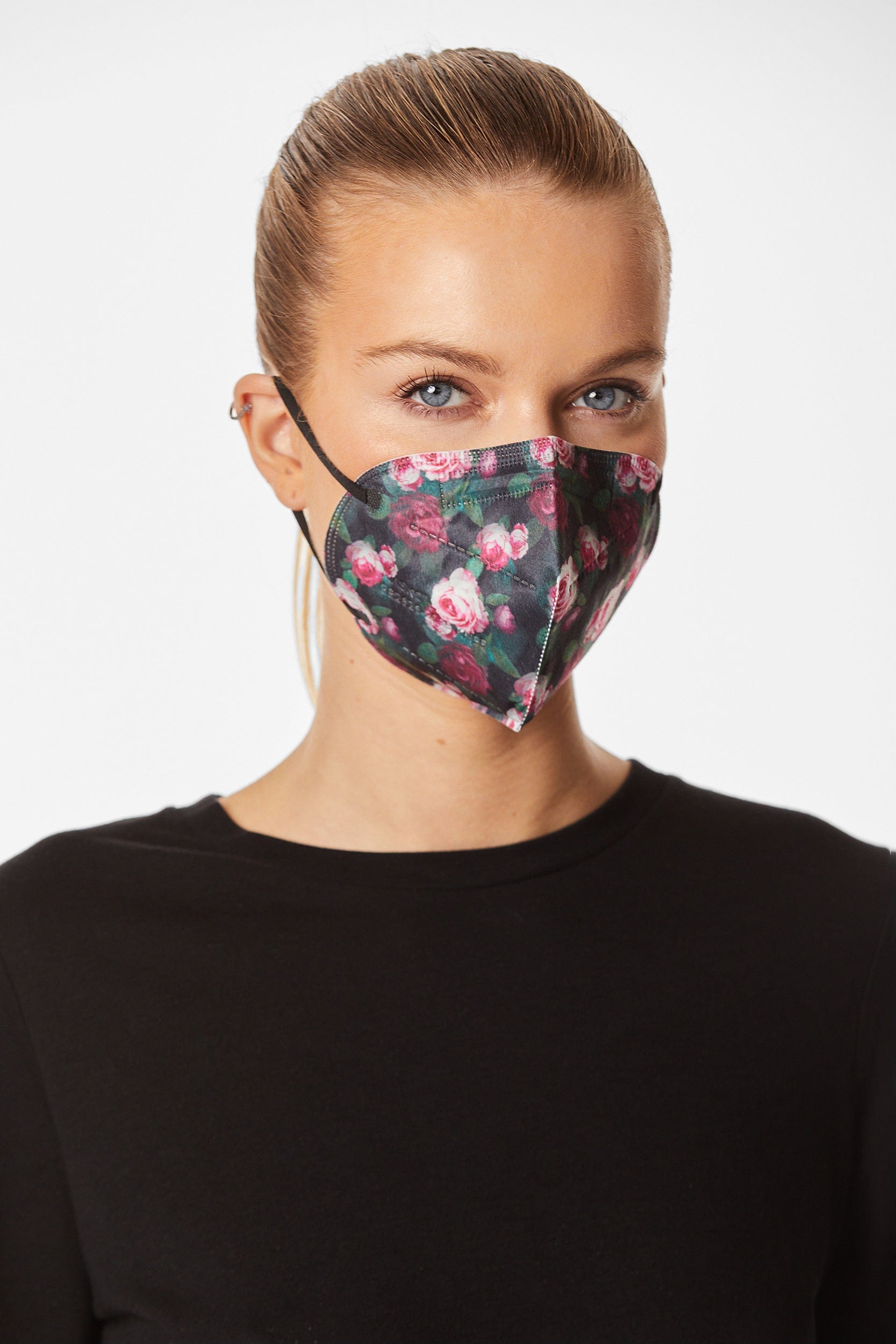 Woman wearing stylish rose printed KN95 face mask, with high quality breathable fabric.