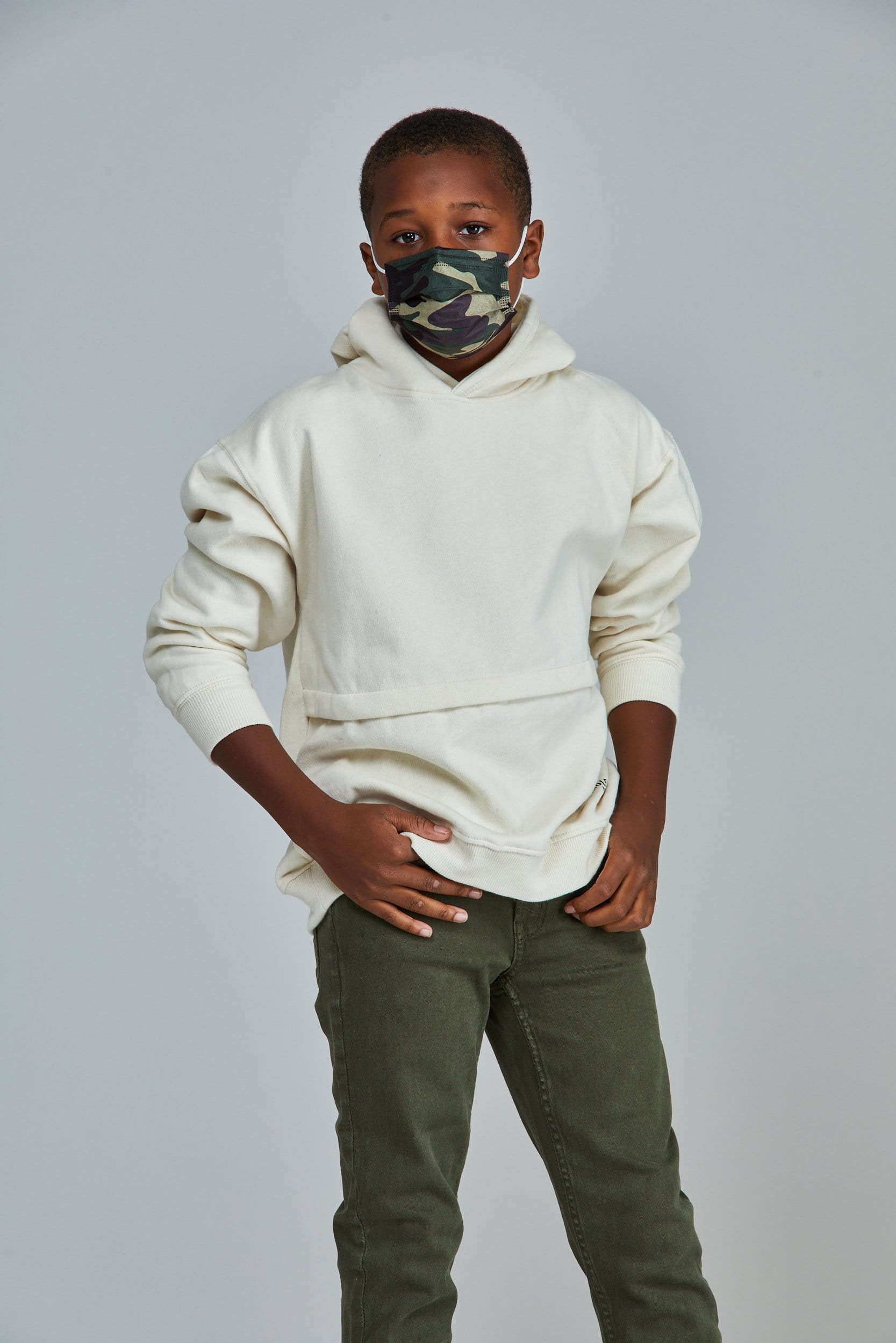 Child wearing stylish Green Camo Pleated face mask, with three layers & high quality breathable fabric.