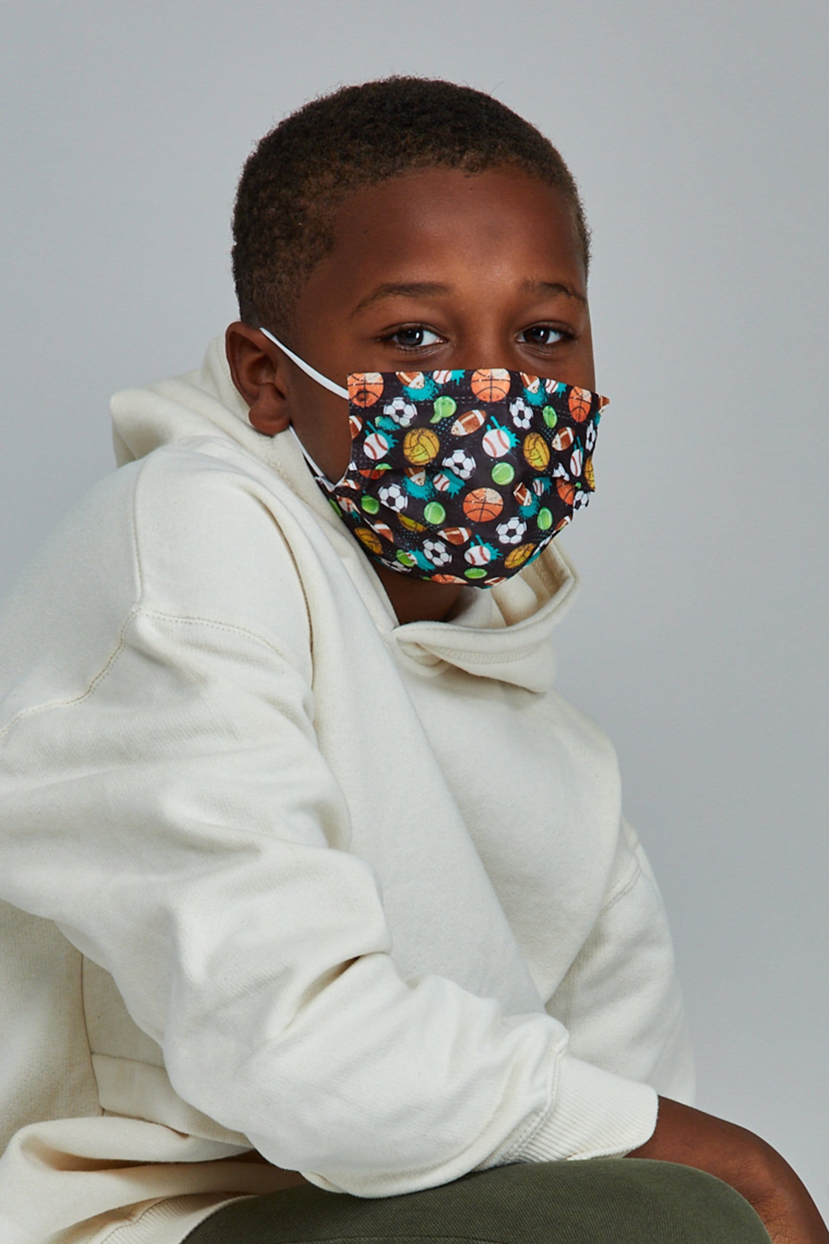 Child wearing stylish Sports Themed Pleated face mask, with three layers & high quality breathable fabric.