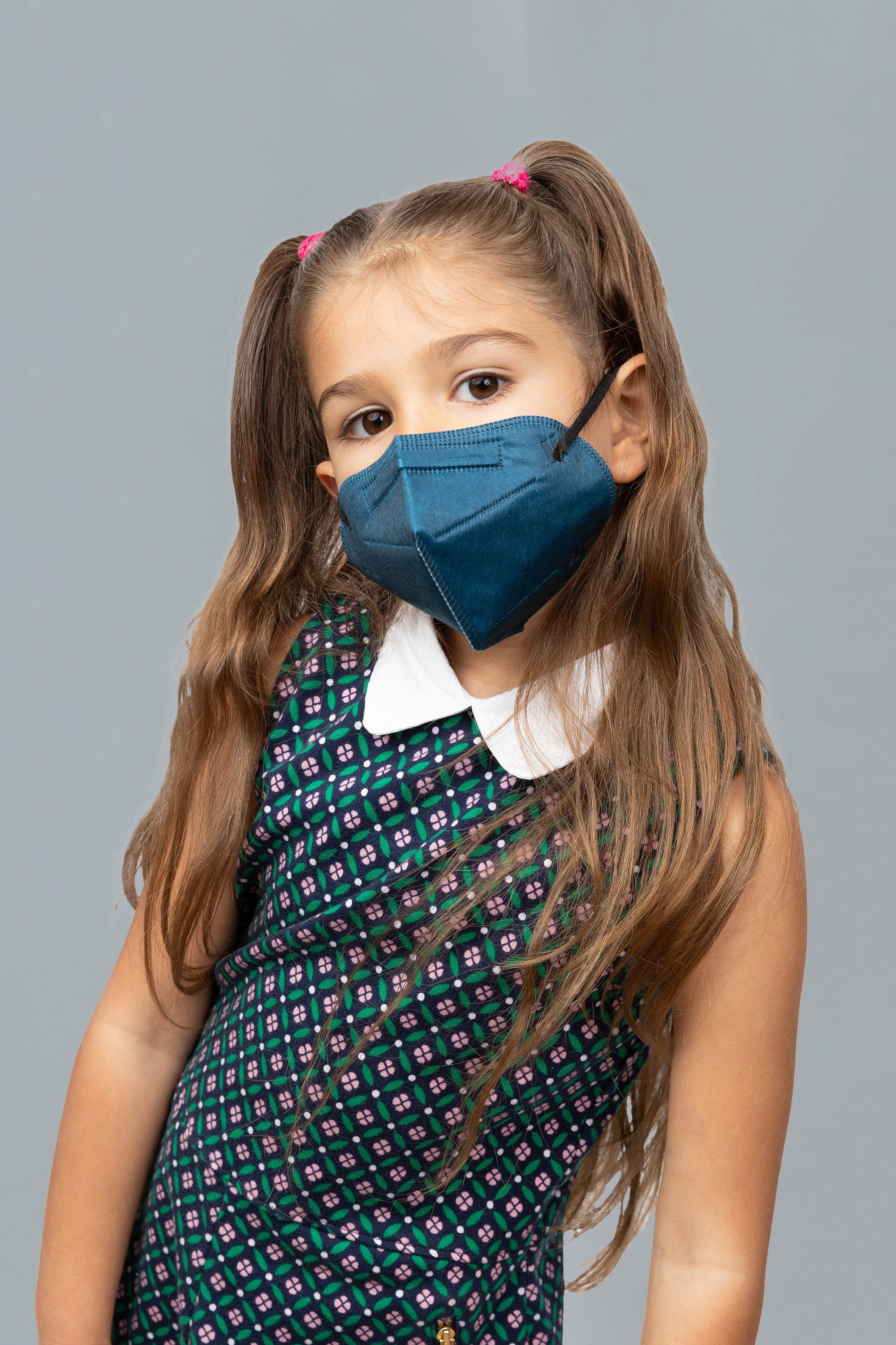 Child wearing stylish kid sized Navy Blue KN95 face mask, with high quality breathable fabric.