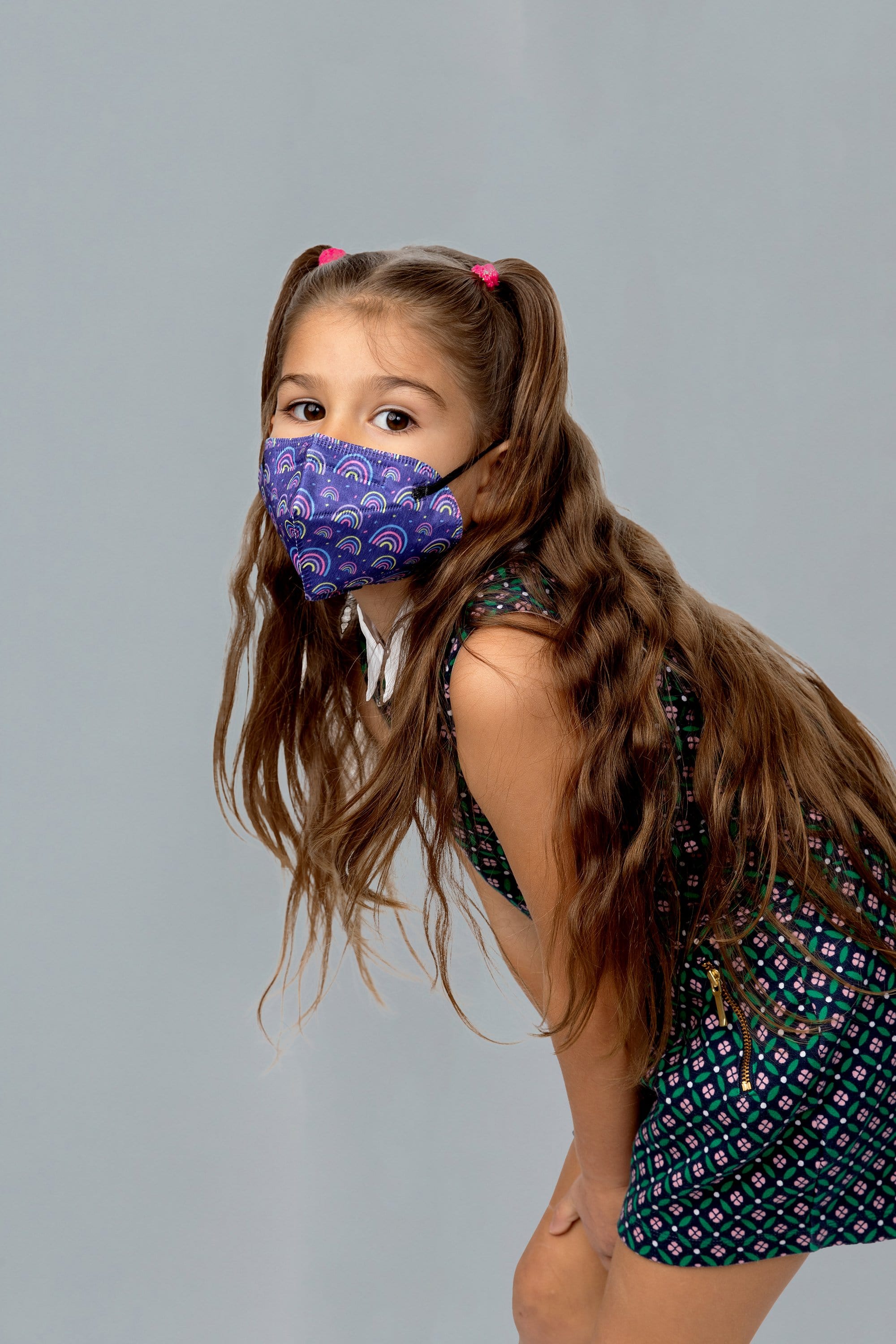 Child wearing stylish kid sized Rainbow Printed Blue KN95 face mask, with high quality breathable fabric. 